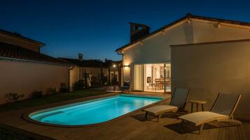Una piscina al aire libre, tumbonas