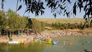 Una zona concurrida a orillas del lago, con barcos, estructuras inflables y gente disfrutando del agua.