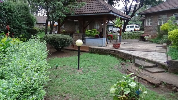 A well-maintained garden with a gazebo, a lawn, and a stone pathway. - Kolping Guest House (Nairobi)