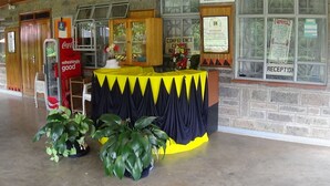 A reception area with a Coca-Cola refrigerator, a conference center sign, and a reception sign. - Kolping Guest House (Nairobi)