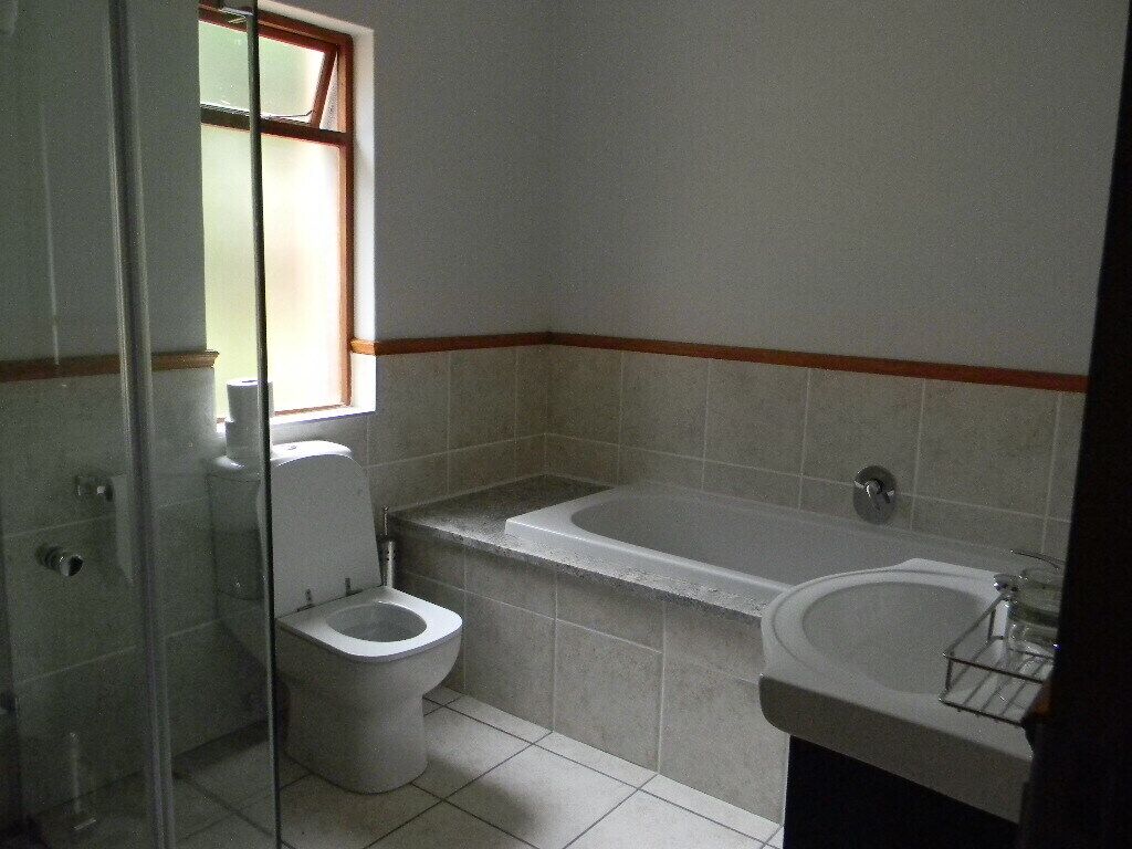 Une salle de bain avec des toilettes, une baignoire et un lavabo.