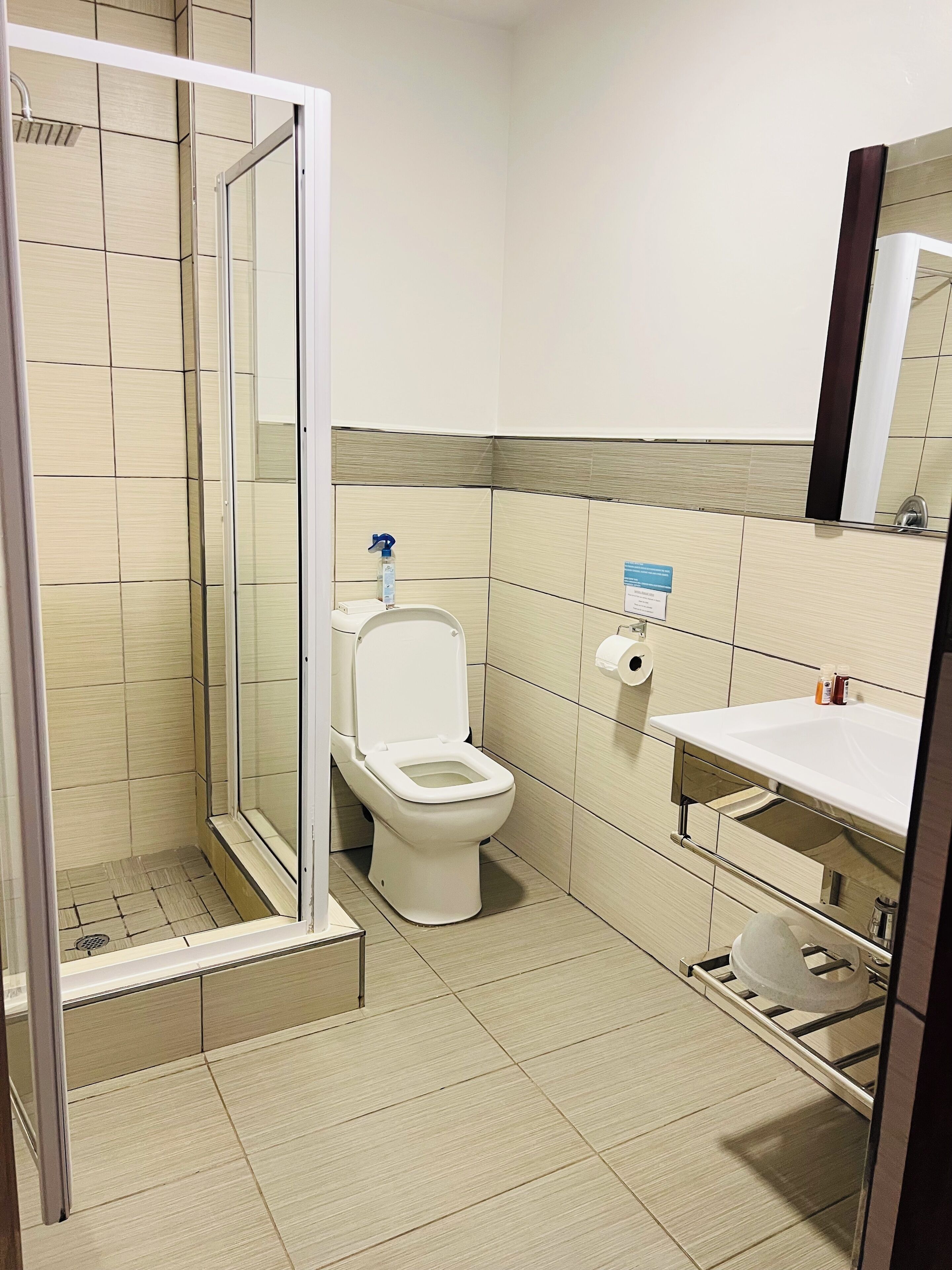 Un baño moderno con ducha, inodoro y lavabo.