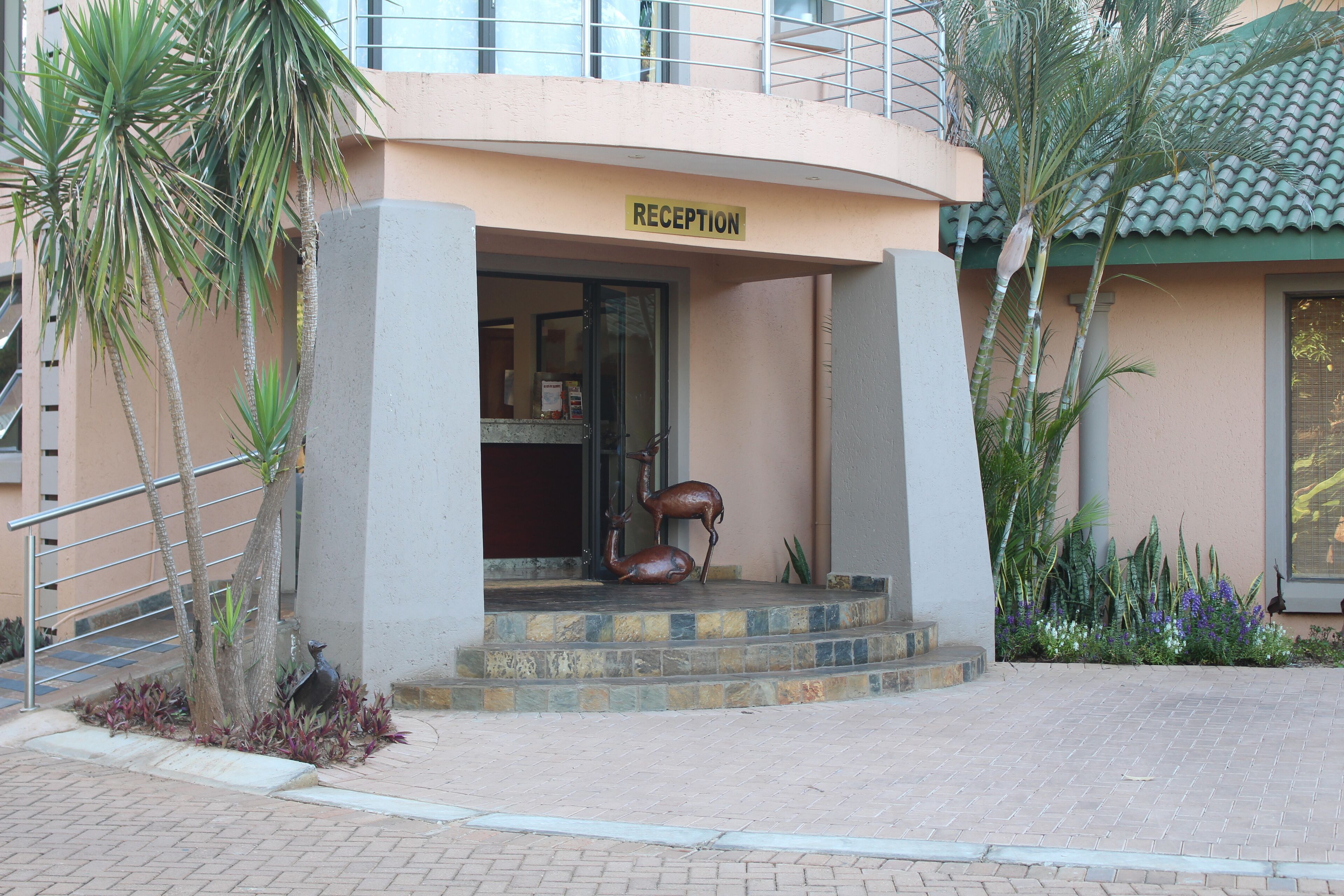 A reception area with a sign, steps, and a statue.