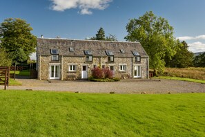 A stone house with multiple rooms, a gravel driveway, and a grassy lawn. - Cardross Estate Holiday Cottages (Stirling)