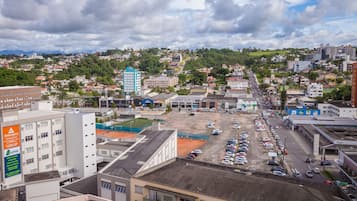 Stadsbeeld met een parkeerplaats, gebouwen en een heuvel in de verte.