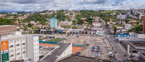 A cityscape with a parking lot, buildings, and a distant hill.