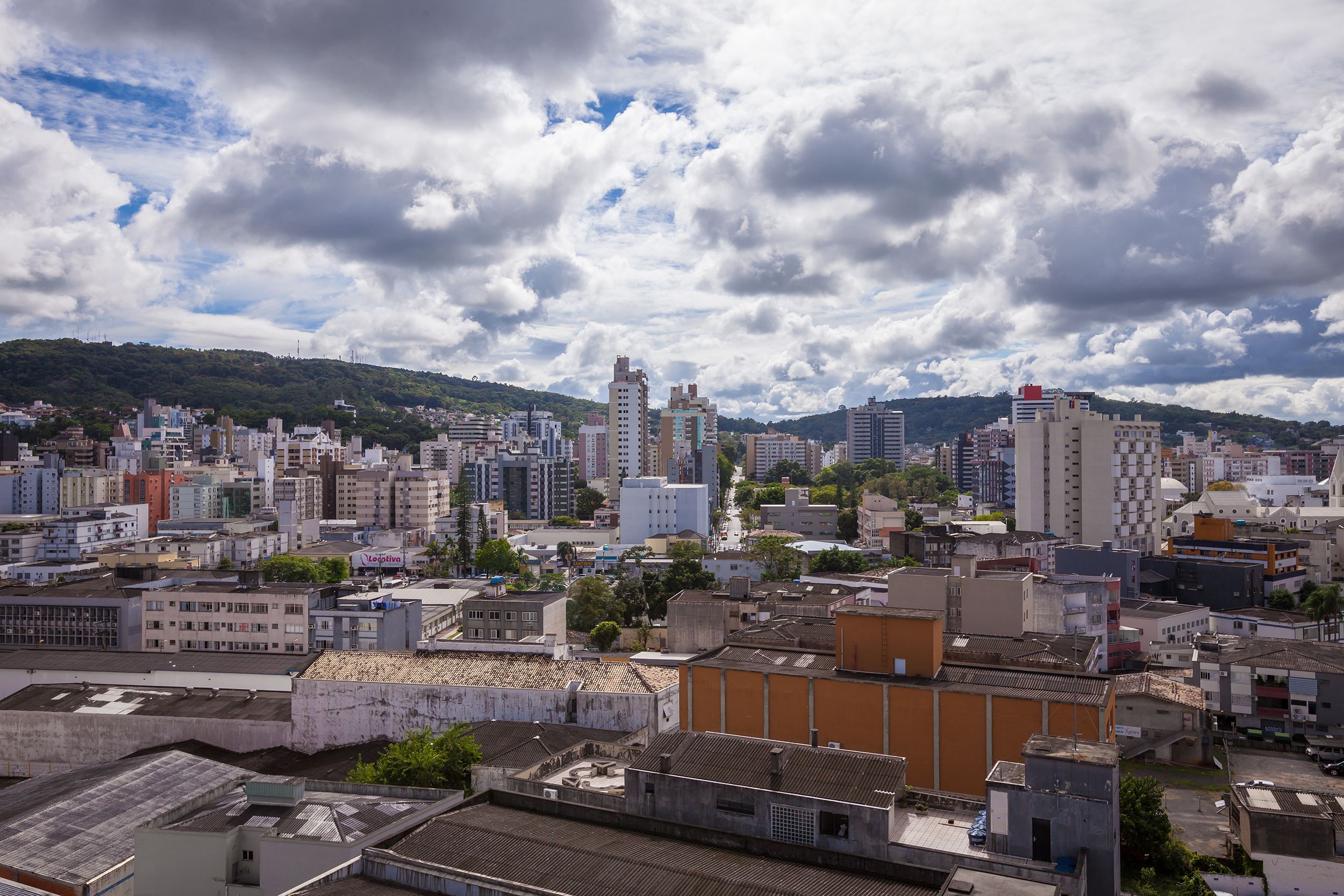 Uma paisagem urbana com diversos estilos de construção, incluindo arranha-céus modernos e edifícios mais antigos e baixos.