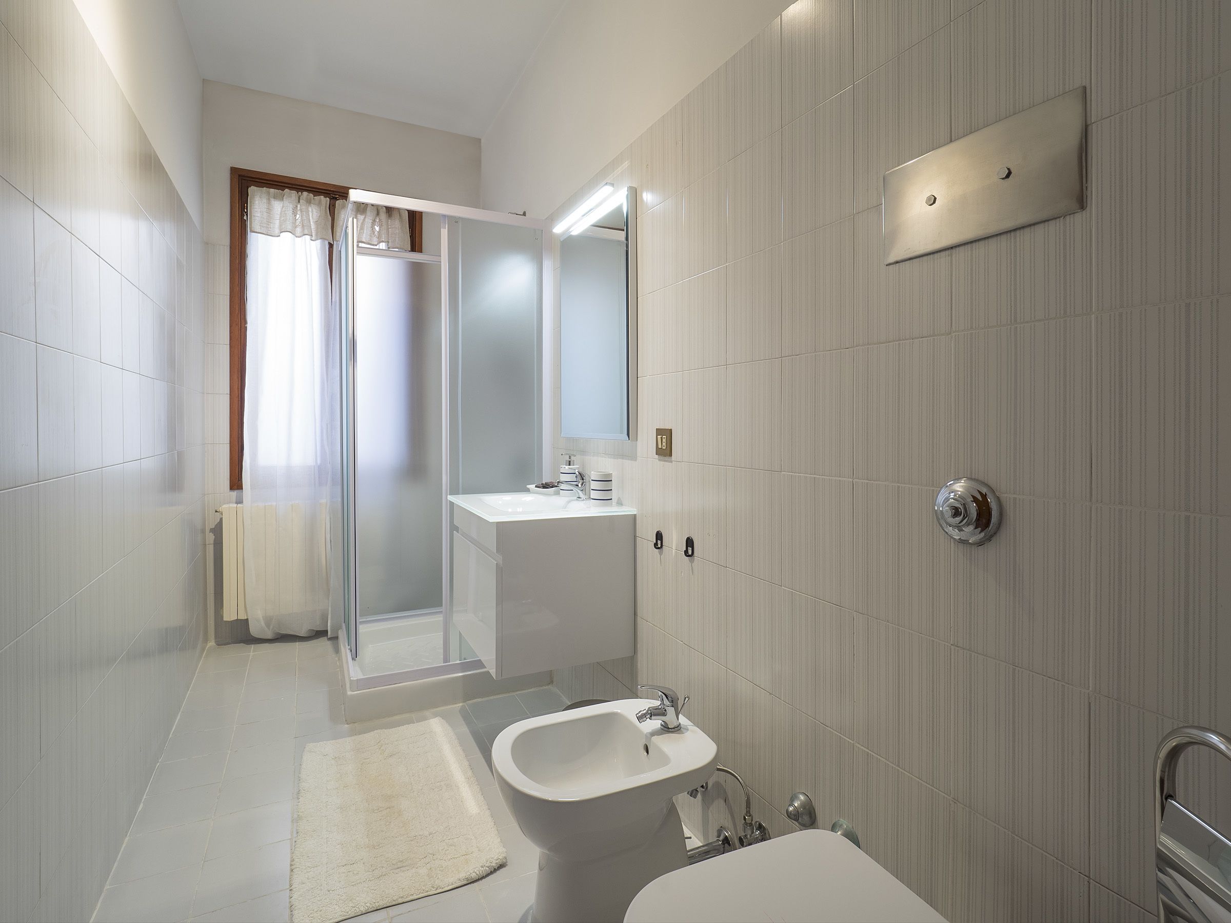 Une salle de bain moderne avec une douche en verre, un lavabo et des toilettes.