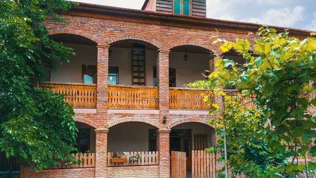 A two-story brick building with multiple balconies and a central courtyard. - Magdalena's House (Mtskheta)