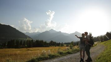 A couple on a gravel path with a mountainous landscape in the background.