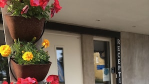 A reception area with a white door and a sign that reads "RECEPTION". - Borrby frö - Bed & Breakfast (Borrby)