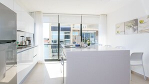 Una cocina moderna con una isla central, ventanas amplias y vistas a la ciudad.