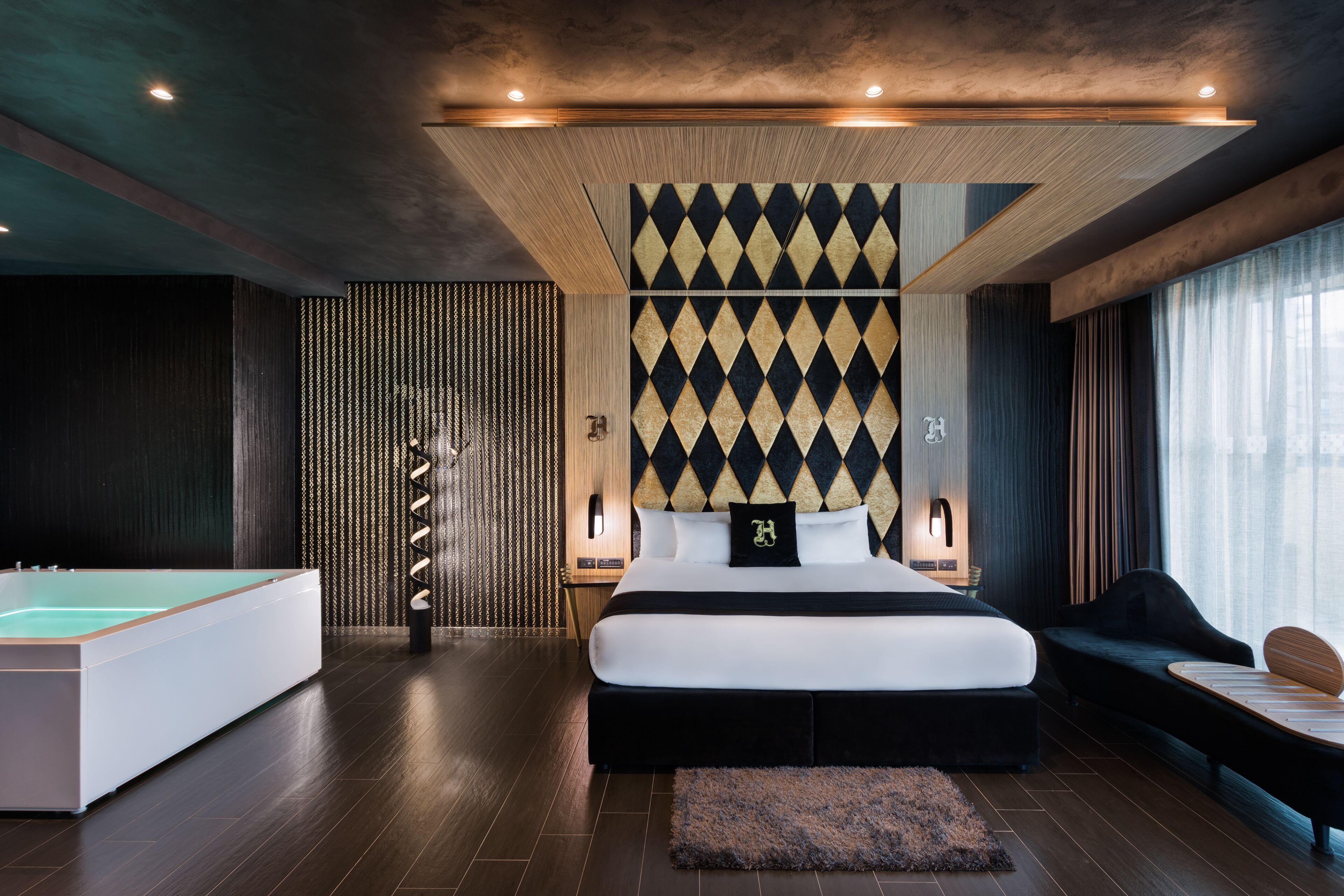 A modern bedroom with a large bed, a pool table, and a unique patterned wall.