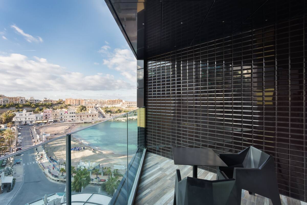Un balcón con vista a la playa y al paisaje urbano.