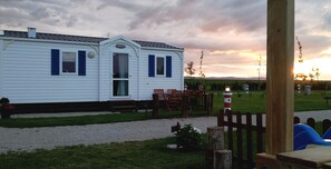 A mobile home with a porch and outdoor seating area. - Camping Rinlo Costa (Ribadeo)