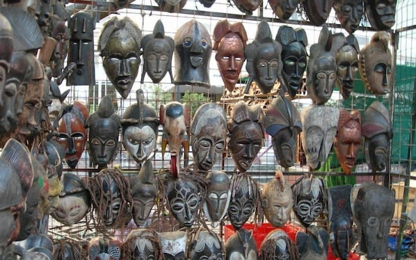 A collection of wooden masks hanging in a display case.