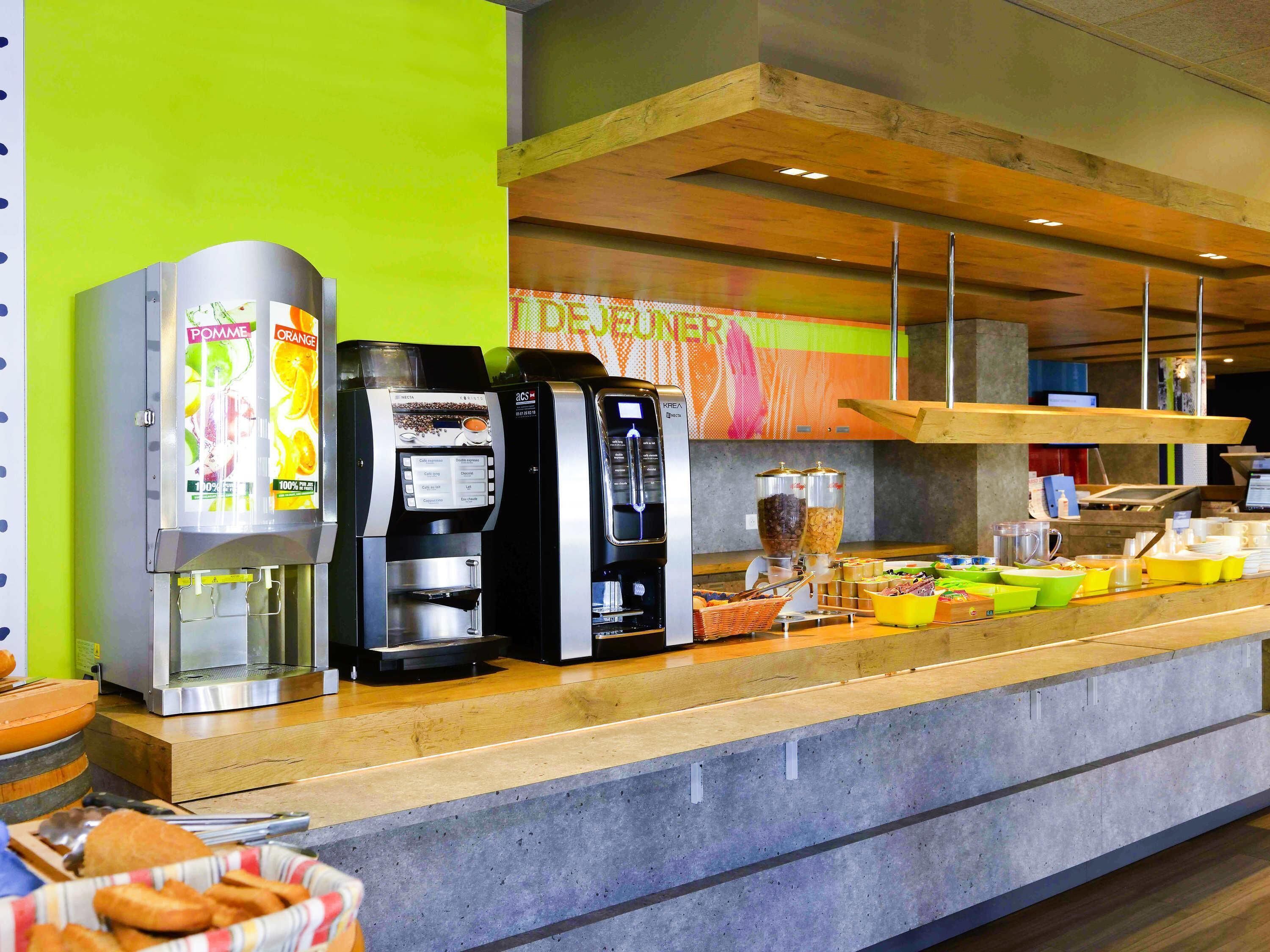 A coffee station with multiple coffee machines and a variety of food items.