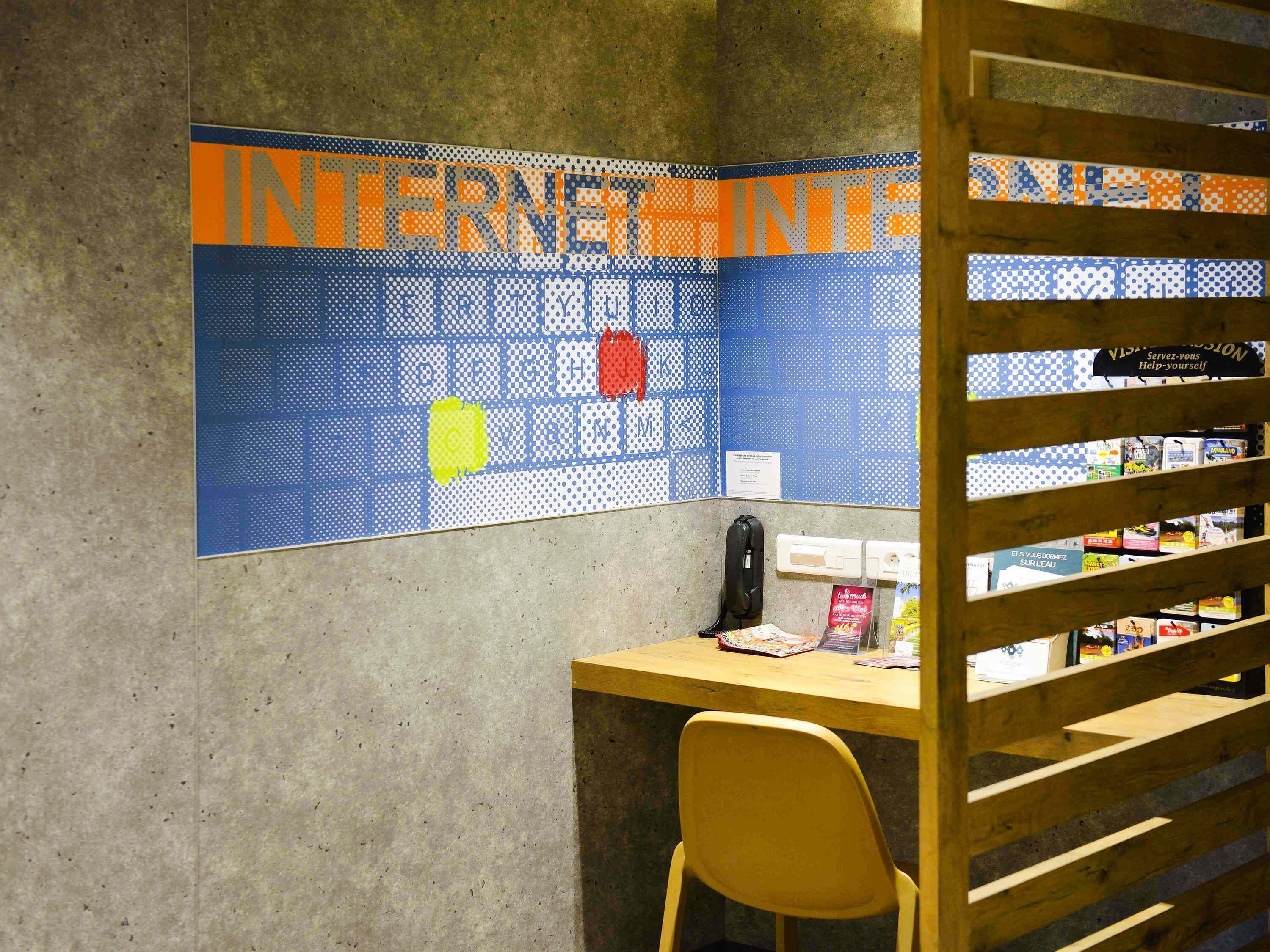 Un espacio de trabajo con una computadora, un teléfono y una silla.