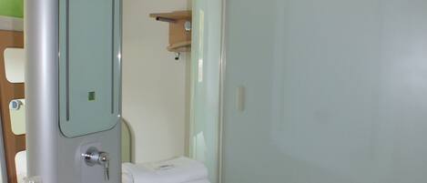 A bathroom with a glass-enclosed shower, a sink, and a toilet.