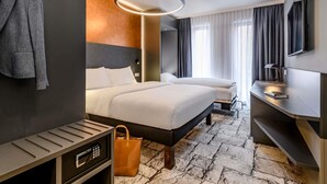 Una habitación de hotel moderna con una cama grande, un escritorio, un televisor y un baño.