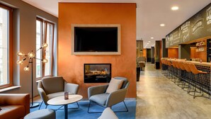 Zona de bar moderna con chimenea, asientos y mostrador.