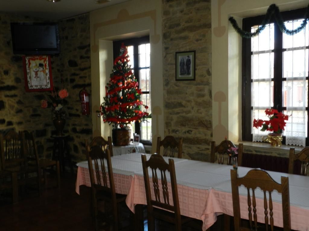 Een eethoek met een stenen muur, een kerstboom en een tafel gedekt voor vier personen.