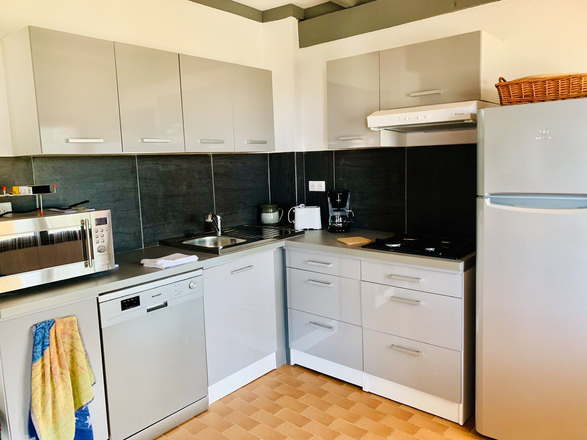 Una cocina moderna con armarios blancos, lavavajillas, estufa y refrigerador.