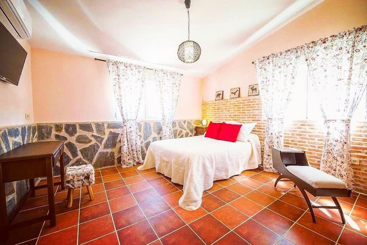 Une chambre à coucher avec un lit, un bureau, une chaise et un téléviseur.