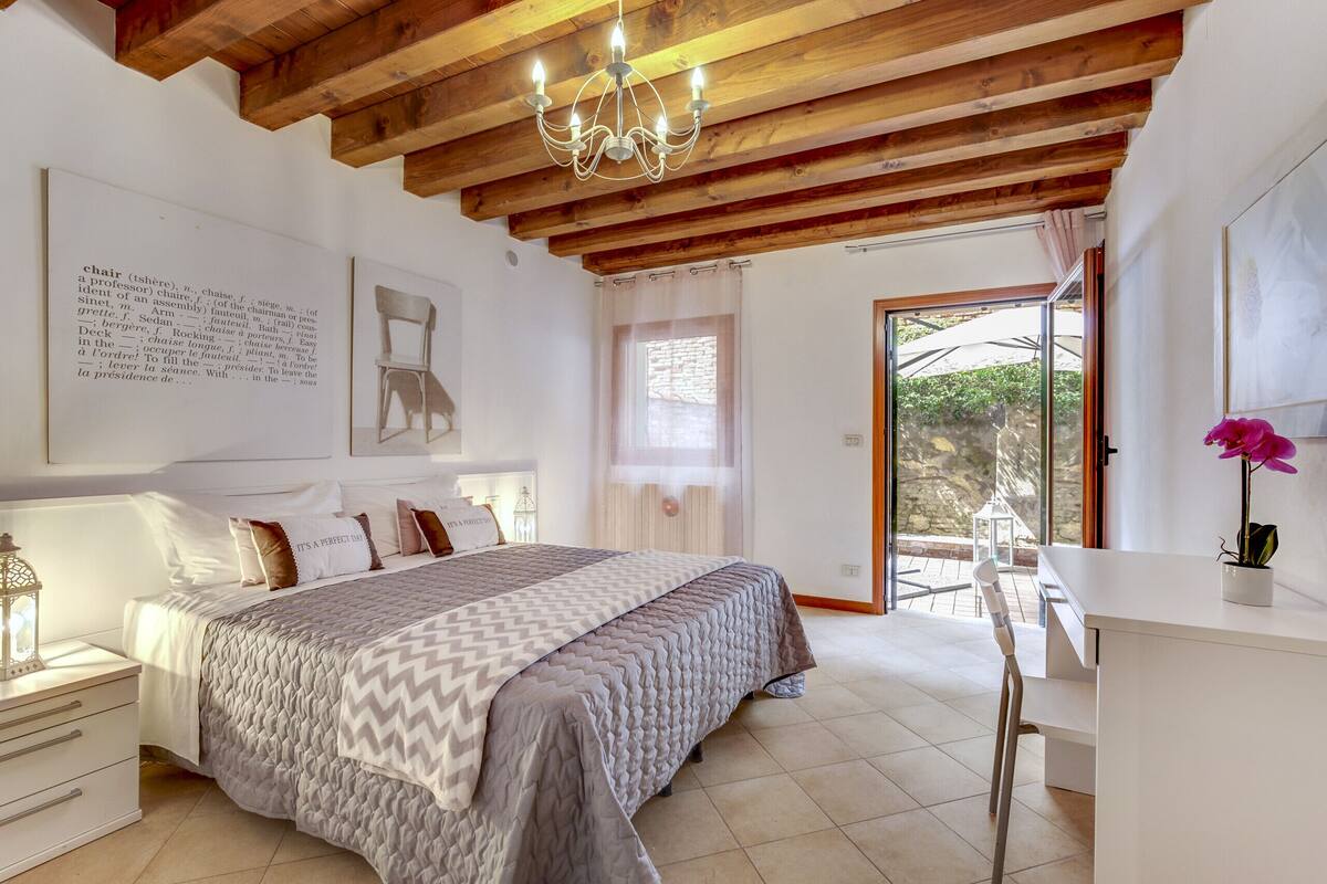 A bedroom with a bed, bedside table, and a desk area.