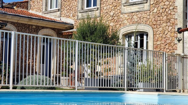 A stone building with a swimming pool in front. - Villa des roses (Luçon)