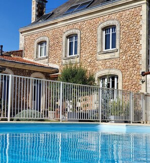 A stone building with a swimming pool in front. - Villa des roses (Luçon)