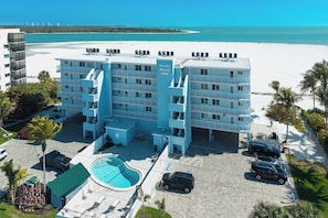 A multi-story hotel with a pool, located near a beach. - Come Stay at Beautiful Gulf Front Castle Beach Condo 302 on Fort Myers Beach! (Fort Myers Beach)