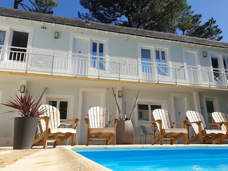 Outdoor pool, open 11:00 AM to 7:00 PM, pool loungers. Le Bercail