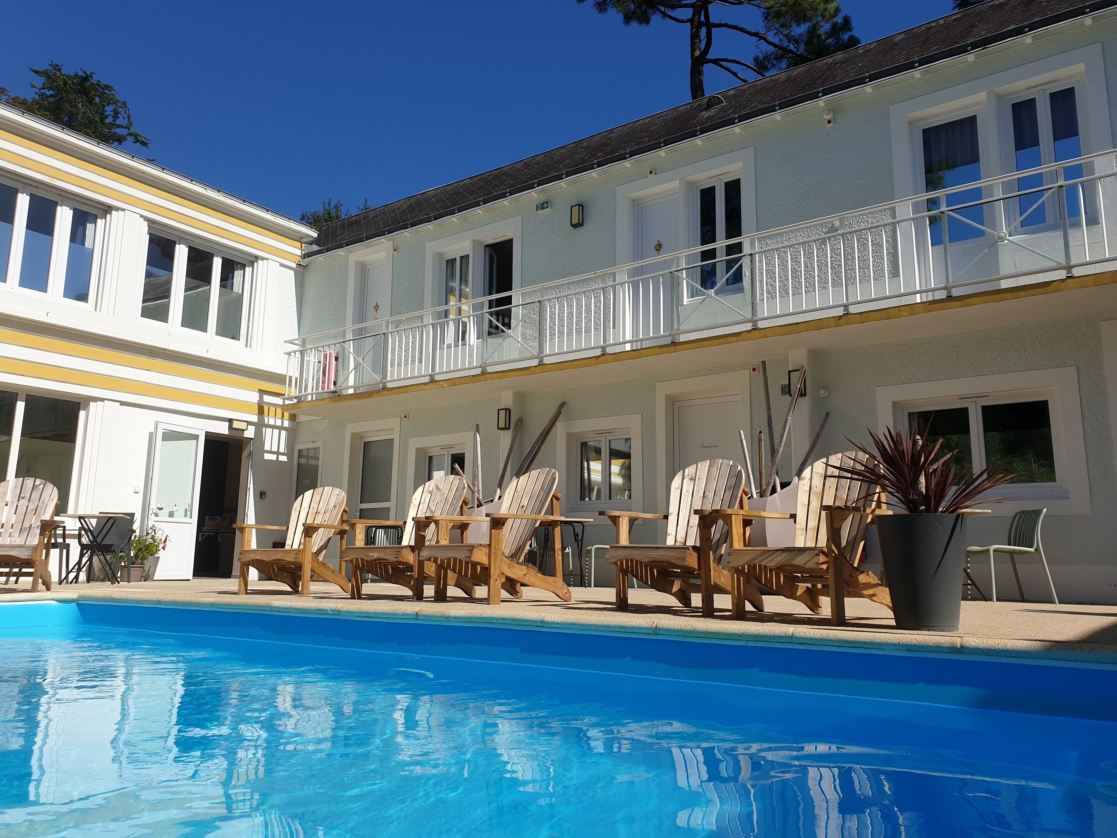 Een buitenzwembad, ligstoelen bij het zwembad