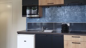 A modern kitchen with a dishwasher, a coffee maker, and a microwave. - Le Bercail (Saint-Jean-de-Monts)
