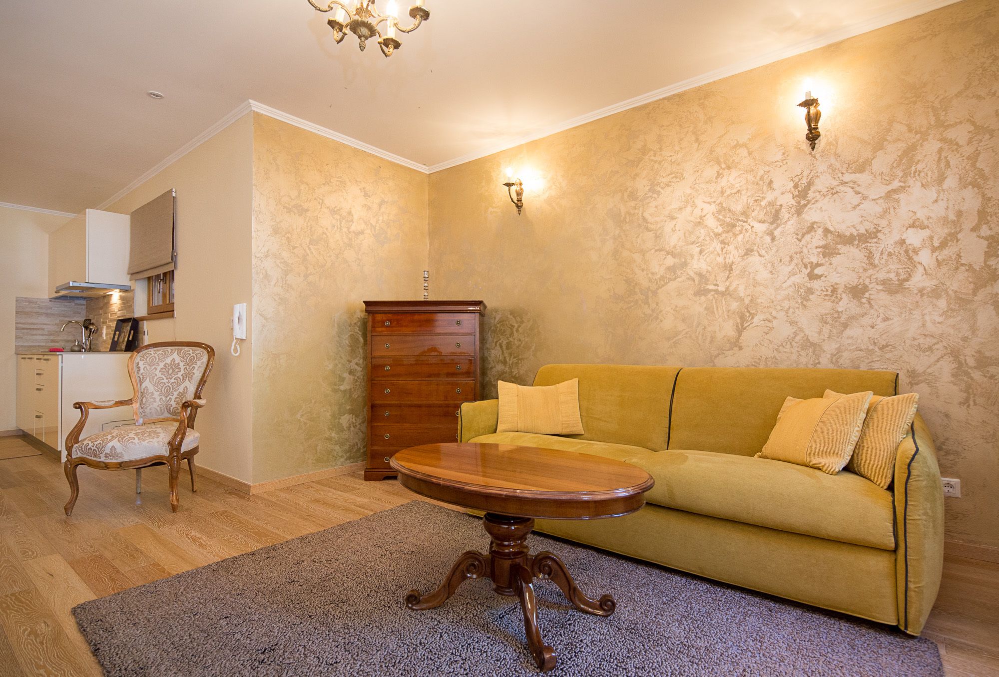 Una sala de estar con una mesa de centro de madera, un sofá amarillo, un mueble de madera y un tapete estampado.
