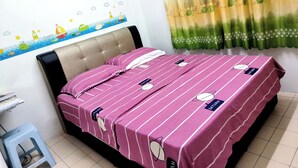 A neatly made bed with striped bedding, a wall-mounted air conditioner, and a decorative wall decal. - H Homestay - Semi D 1000Mbps (1Gbps) Wifi, Astro & Private Parking (Sibu)