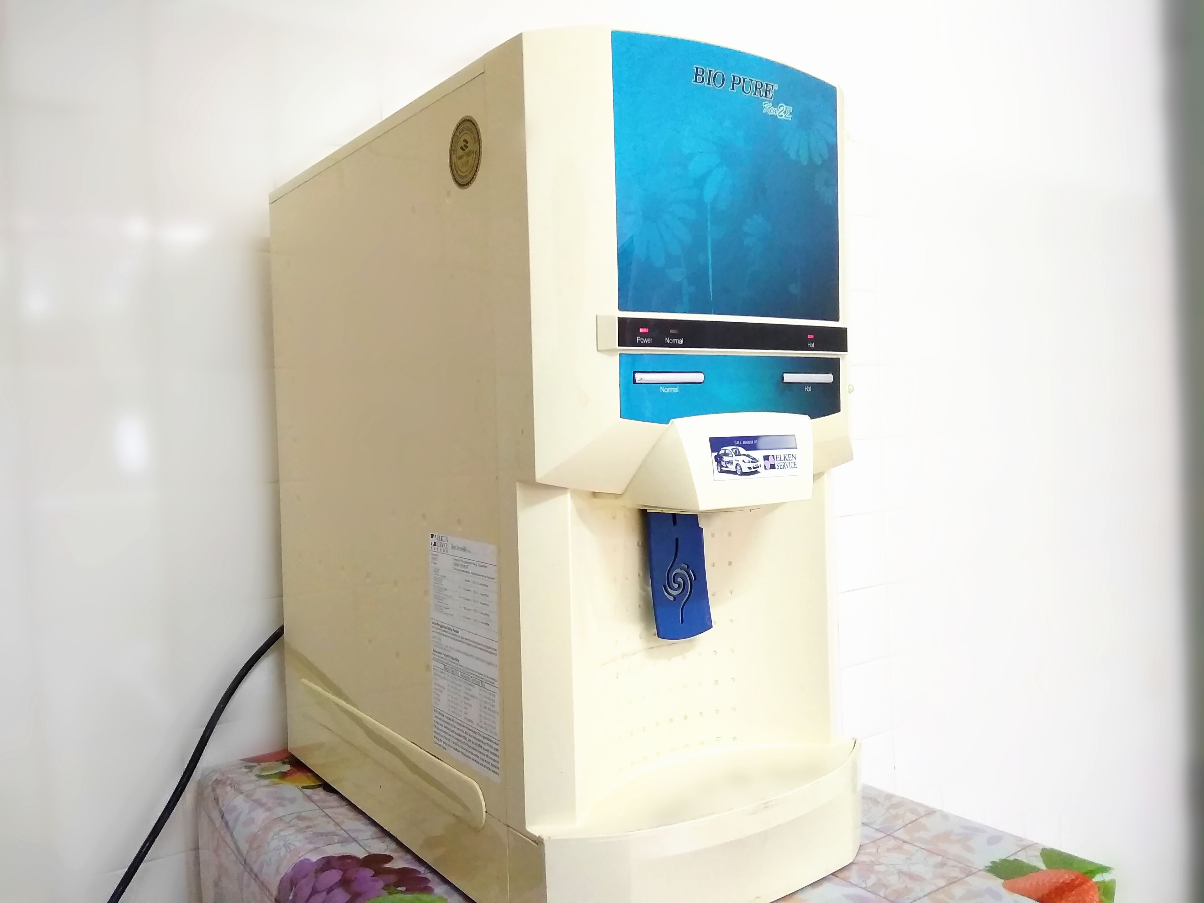 A water dispenser with a blue label, a power button, and a service label for Velken Service.