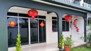 A building with large windows, potted plants, and red decorations. - H Homestay - Semi D 1000Mbps (1Gbps) Wifi, Astro & Private Parking (Sibu)