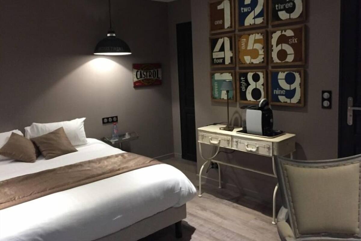 A bedroom with a bed, a desk with a chair, a hanging light, and a wall with numbered decorations.