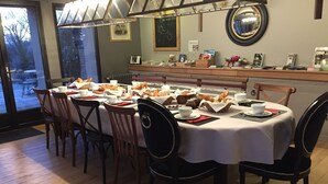 A dining area with a round table set for four, surrounded by wooden chairs. - Le Clos Du Miroir (Courset)