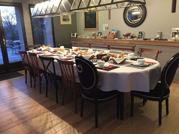 A dining area with a round table set for four, surrounded by wooden chairs.