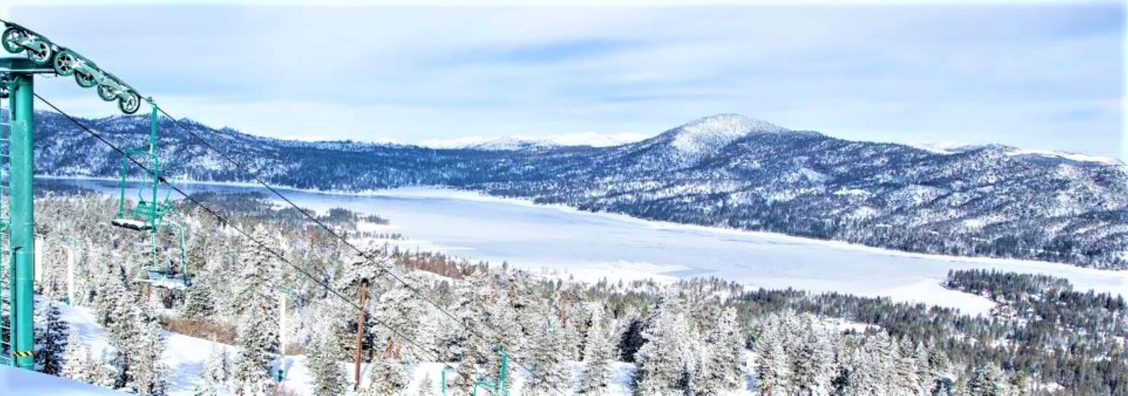 A ski lift with a snowy mountain landscape in the background.