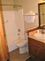 A bathroom with a bathtub, toilet, and sink.