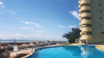 Una piscina cubierta, una piscina al aire libre, sombrillas, tumbonas