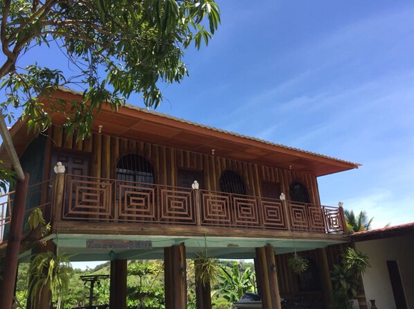 A two-story building with a balcony featuring geometric metal railings.