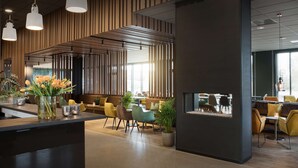 A modern interior with a reception desk, seating area, and large windows allowing natural light.