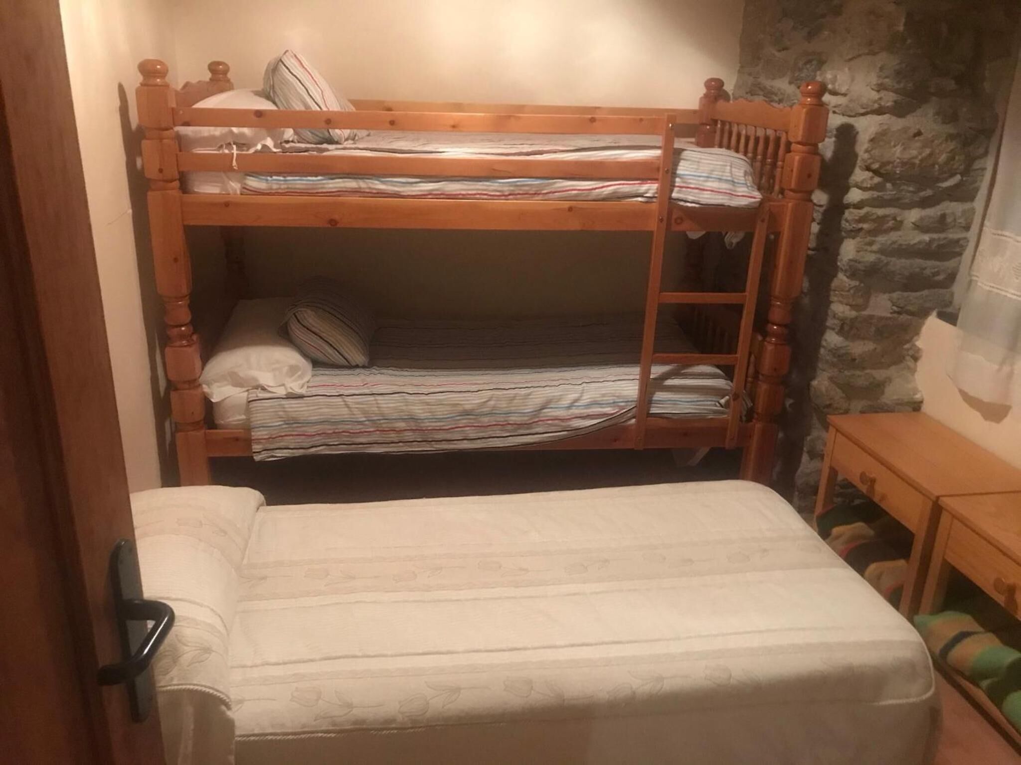 Un lit superposé avec un lit en bas et un lit simple en haut.