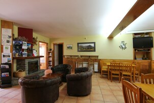 Un salón acogedor con chimenea, sofás de cuero, muebles de madera y un televisor.