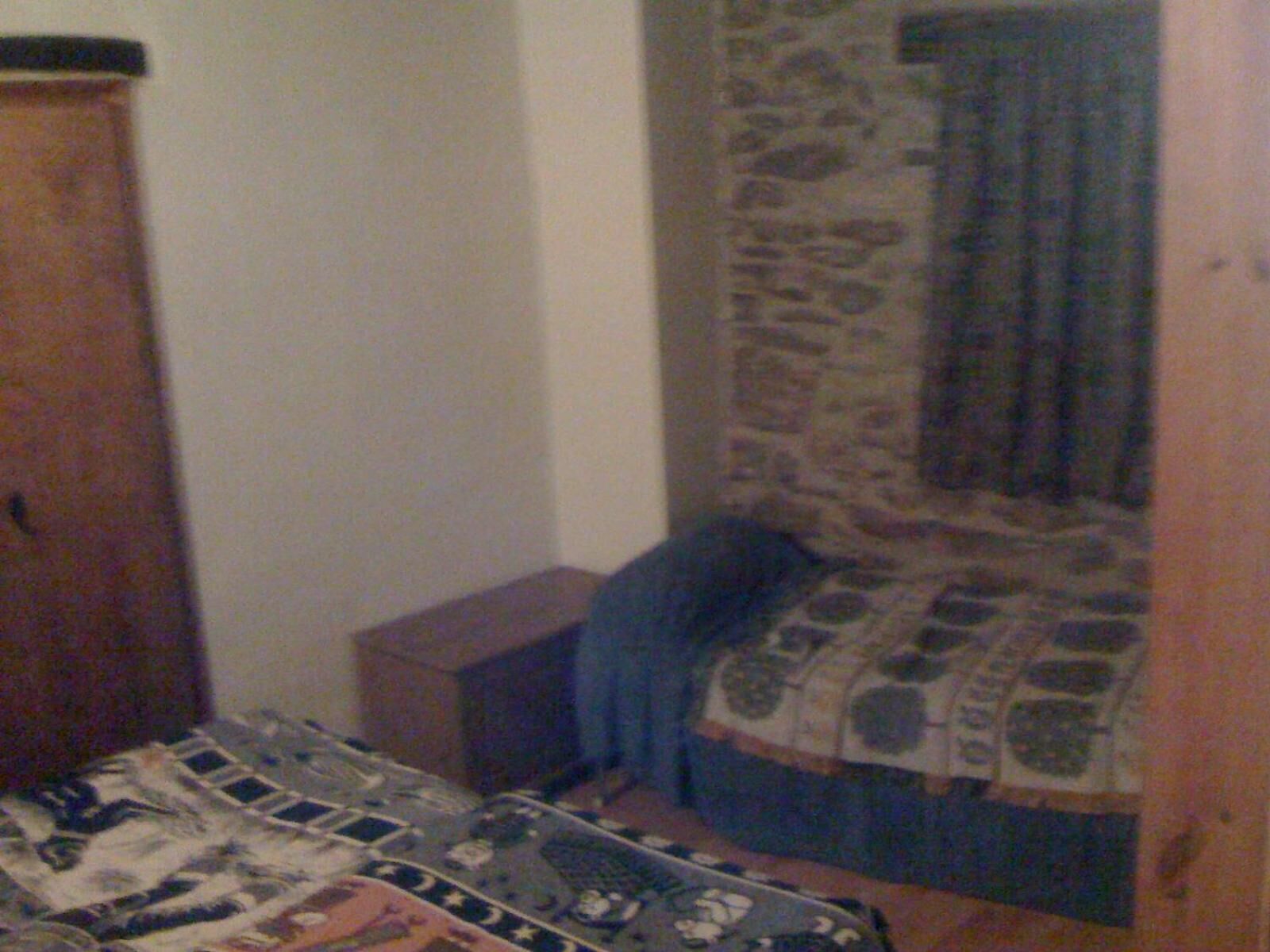 Una camera da letto con un letto, un armadio e una finestra con tenda.